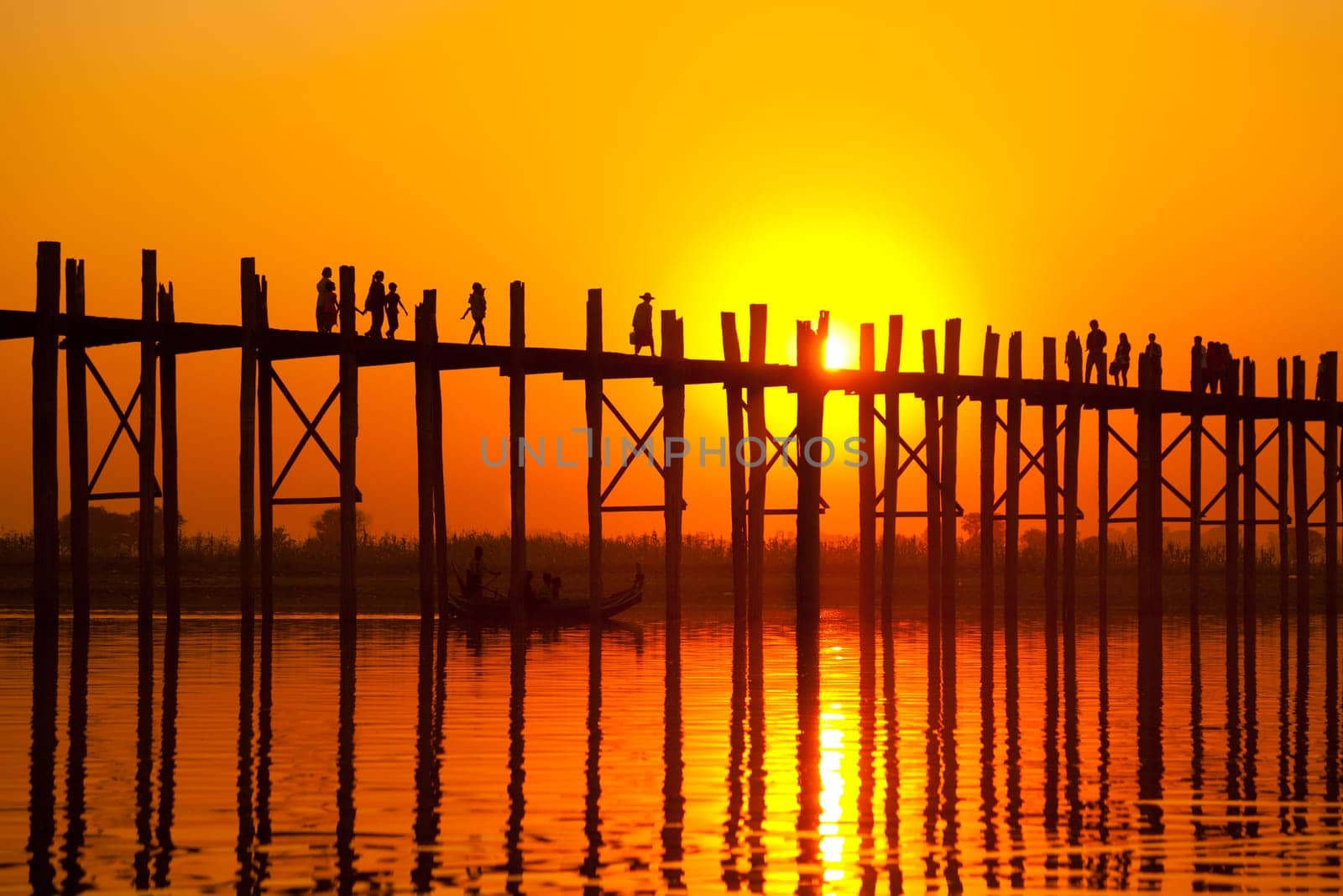 U Bein Bridge at sunset with people crossing Ayeyarwady River, Mandalay, Myanmar