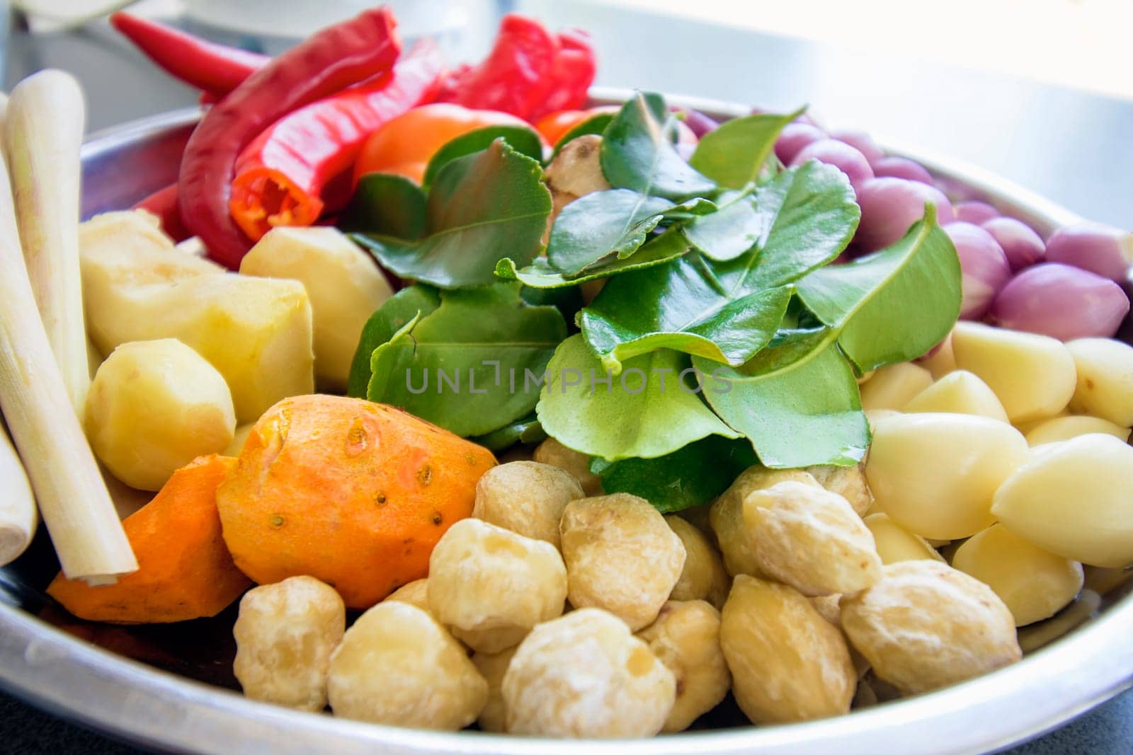 Fresh Ingredients for Cooking Southeast Asian Curry Dish Sauce with Chili Peppers Ginger Lemon Grass Onions Shallots Lime Leaves Garlic Candle Nut Tomato Closeup Macro