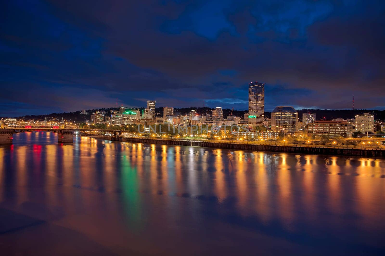Portland Oregon Downtown City Skyline Along Willamette River Waterfront at Evening Blue Hour with Storm Clouds Panorama
