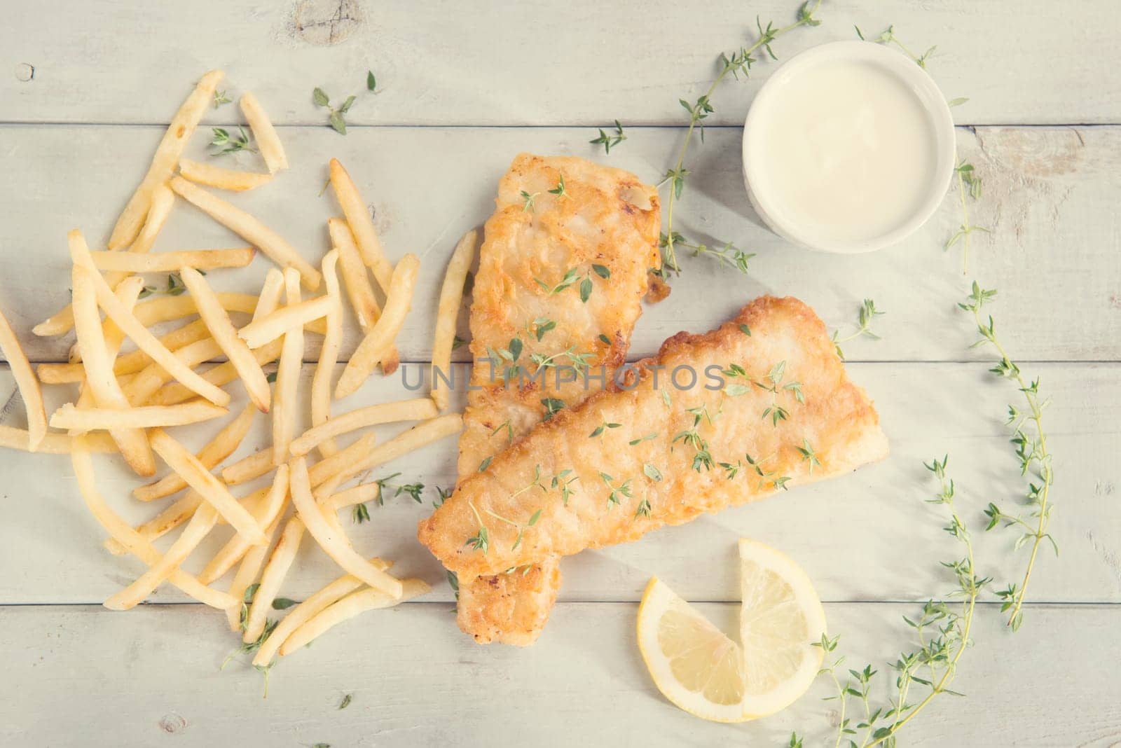 Fish and chips. Above view fried fish fillet with french fries on wooden background, vintage tone.