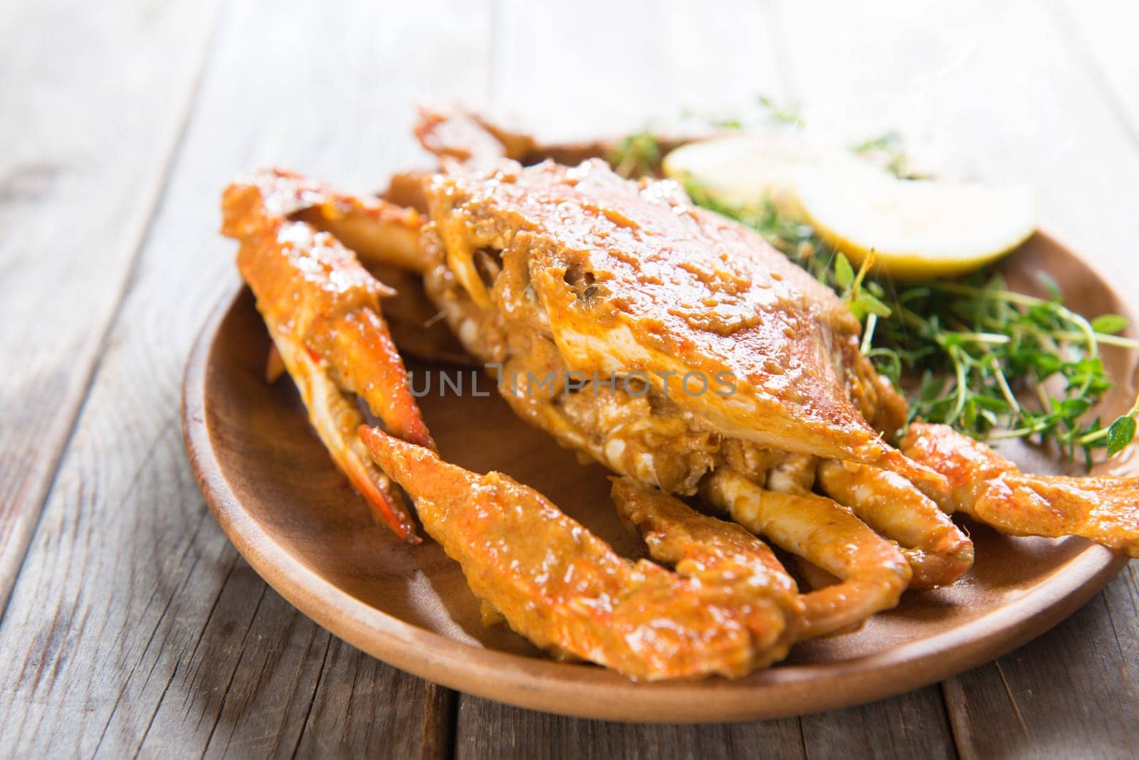 Cooked delicious hot and spicy sauce blue crab, on wooden background.