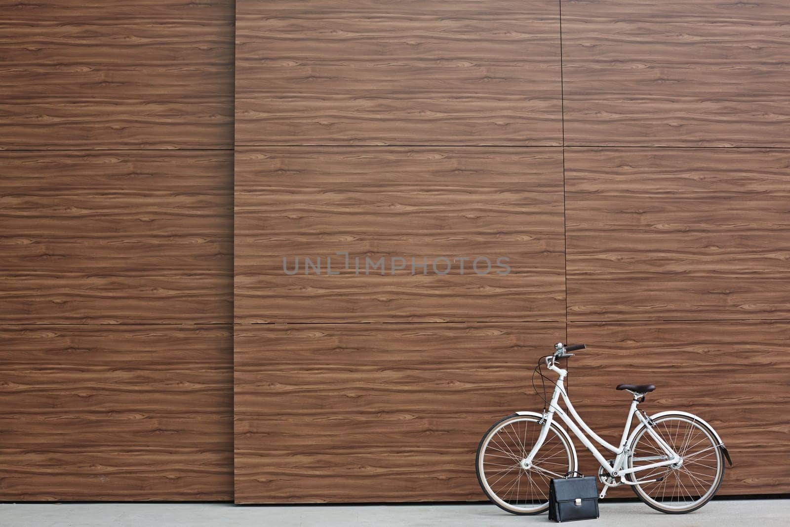 Bicycle and black briefcase against wooden wall
