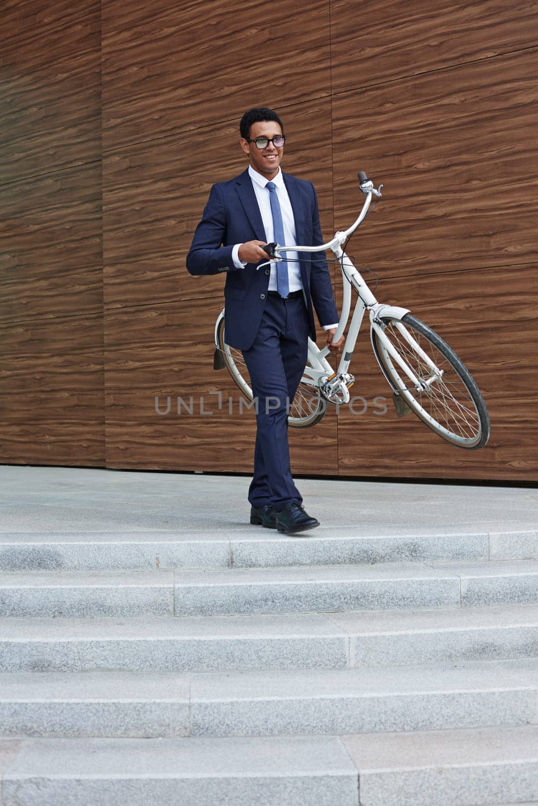 Businessman with bicycle going downstairs outdoors