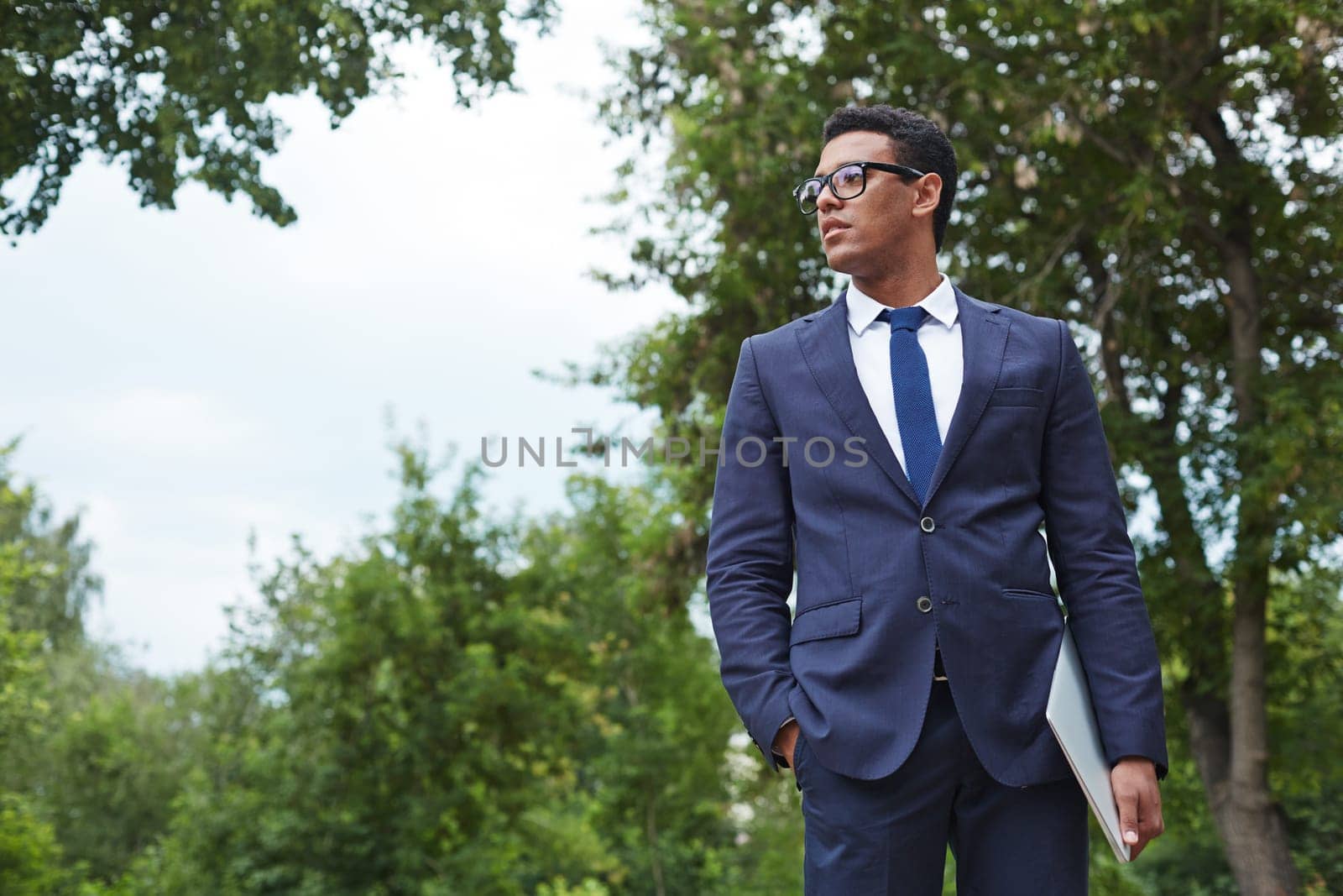 Young businessman with touchpad standing in park