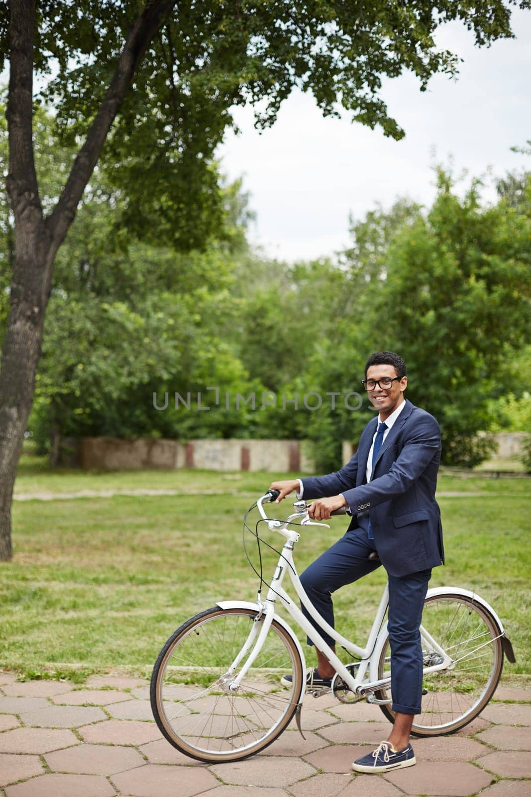 Young businessman sitting on bicycle and looking at camera