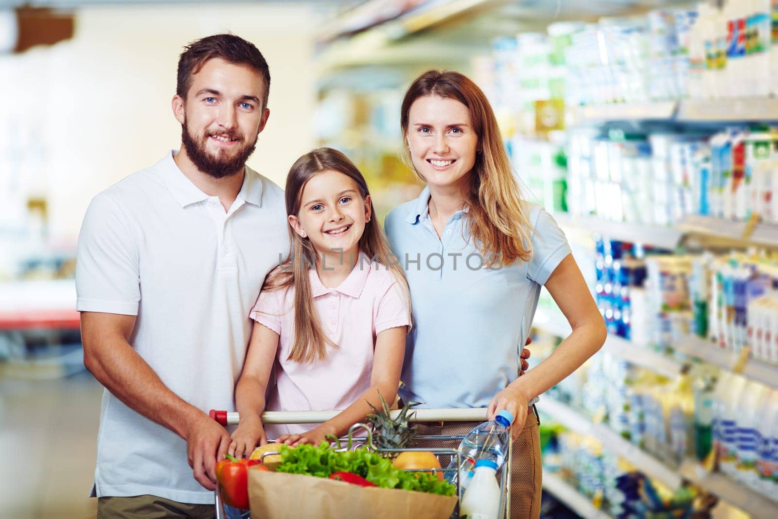 Cheerful family with shopping cart buying products