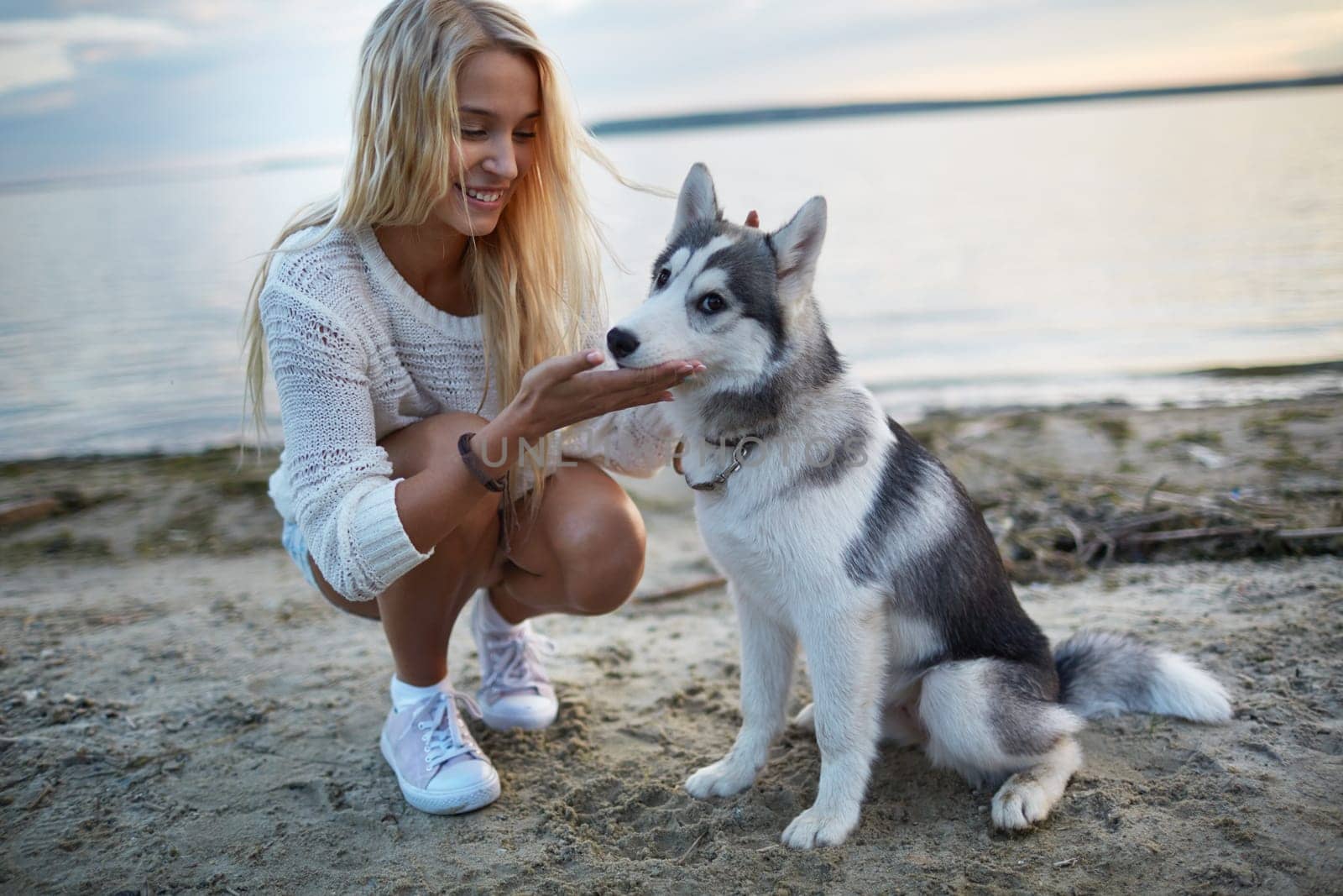 Pretty girl spending summer vacation by the seaside with her dog