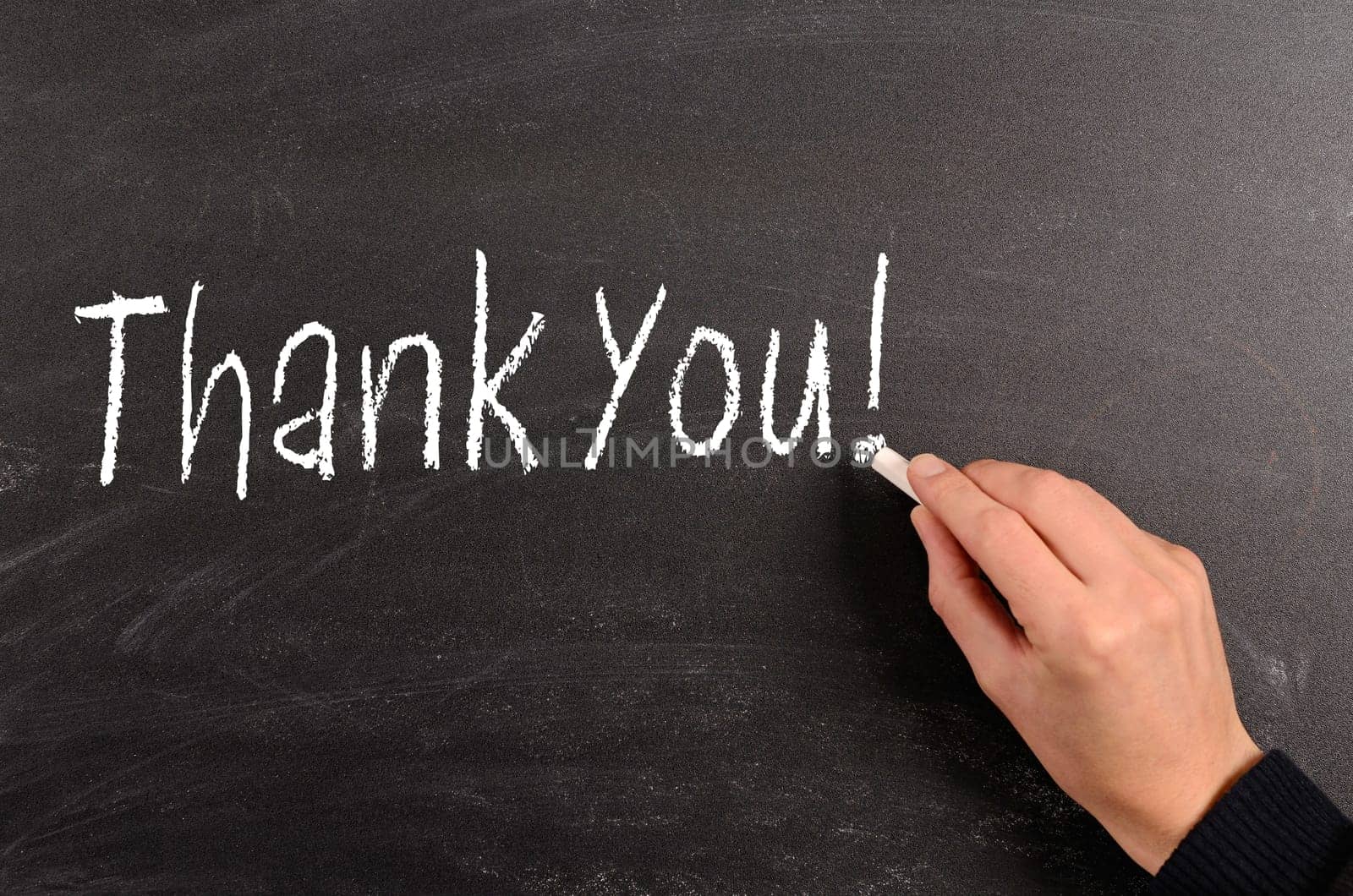 Hand writing with chalk Thank You! on a blackboard