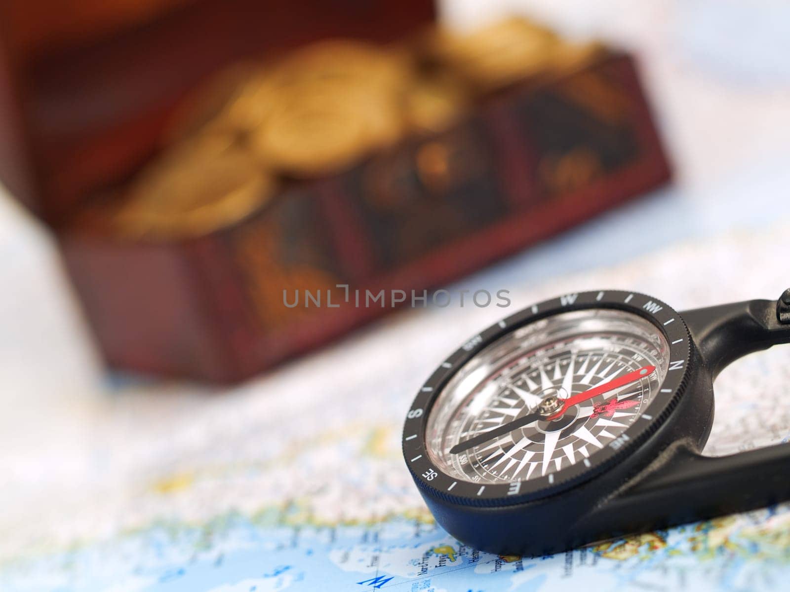 Treasure chest with gold coins, ocean map and a compass