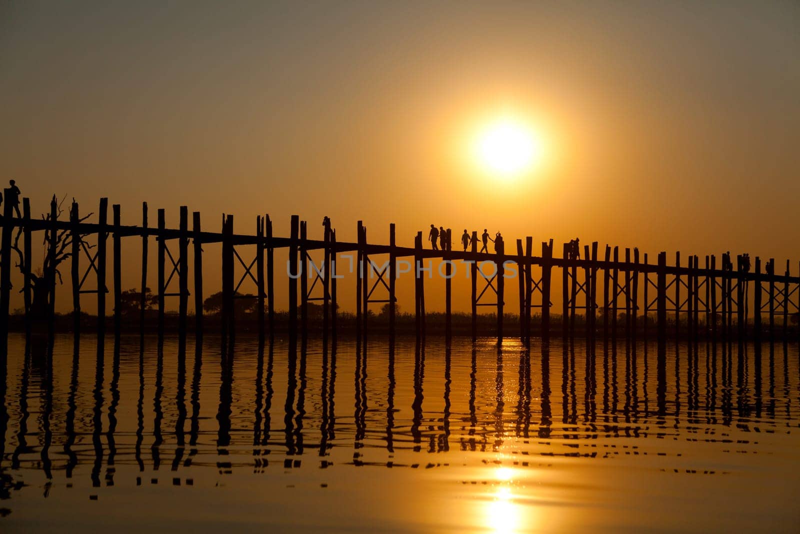 U Bein Bridge at sunset with people crossing Ayeyarwady River, Mandalay, Myanmar