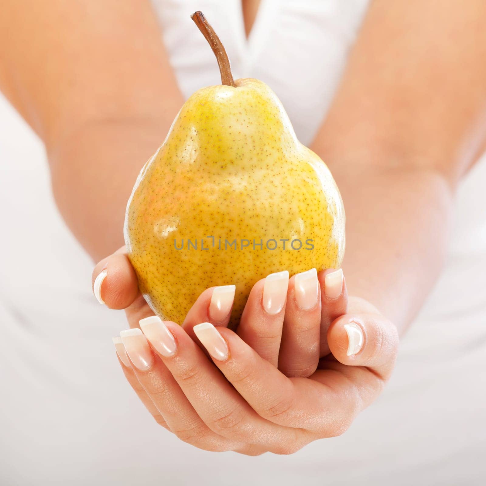 Young woman holding pear in her hands, isolated on white