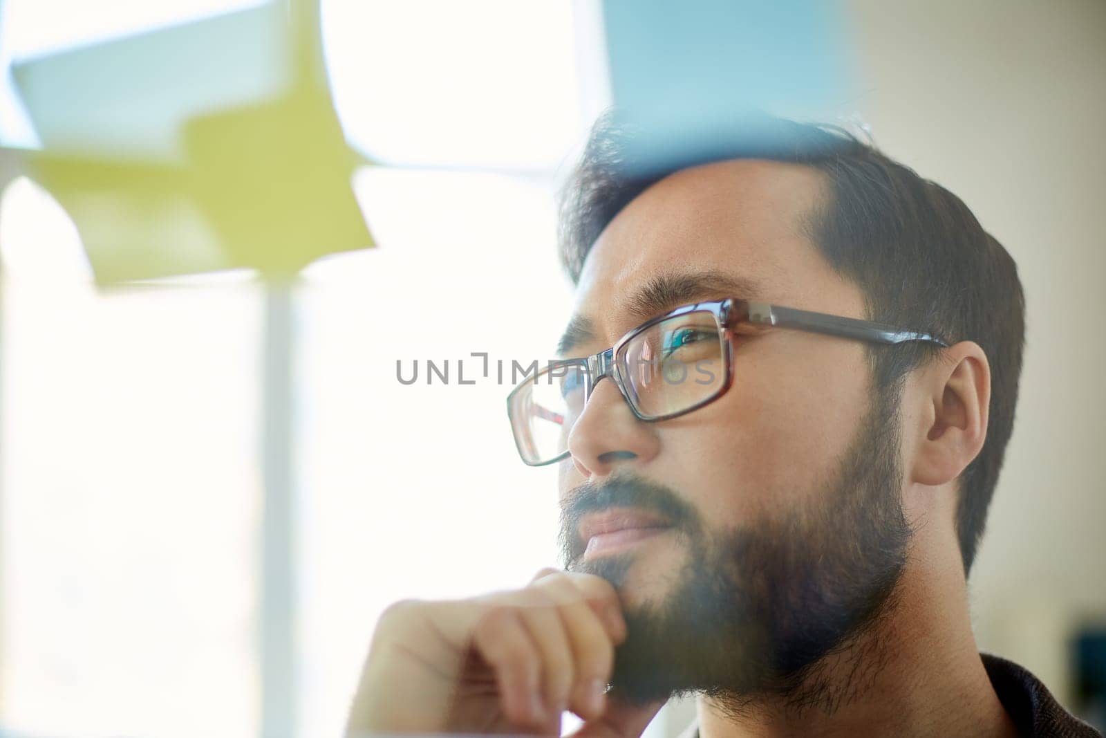 Pensive businessman looking at reminder in office