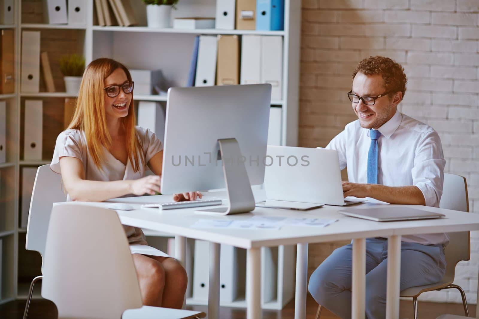 Confident colleagues computing in office