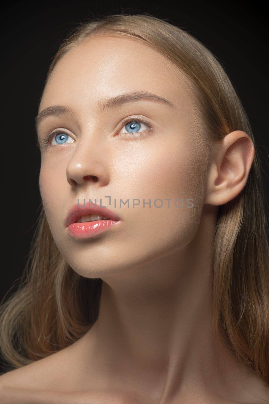 Beautiful face of young blonde woman with blue eyes and clean fresh skin close up. Youth and skin care concept