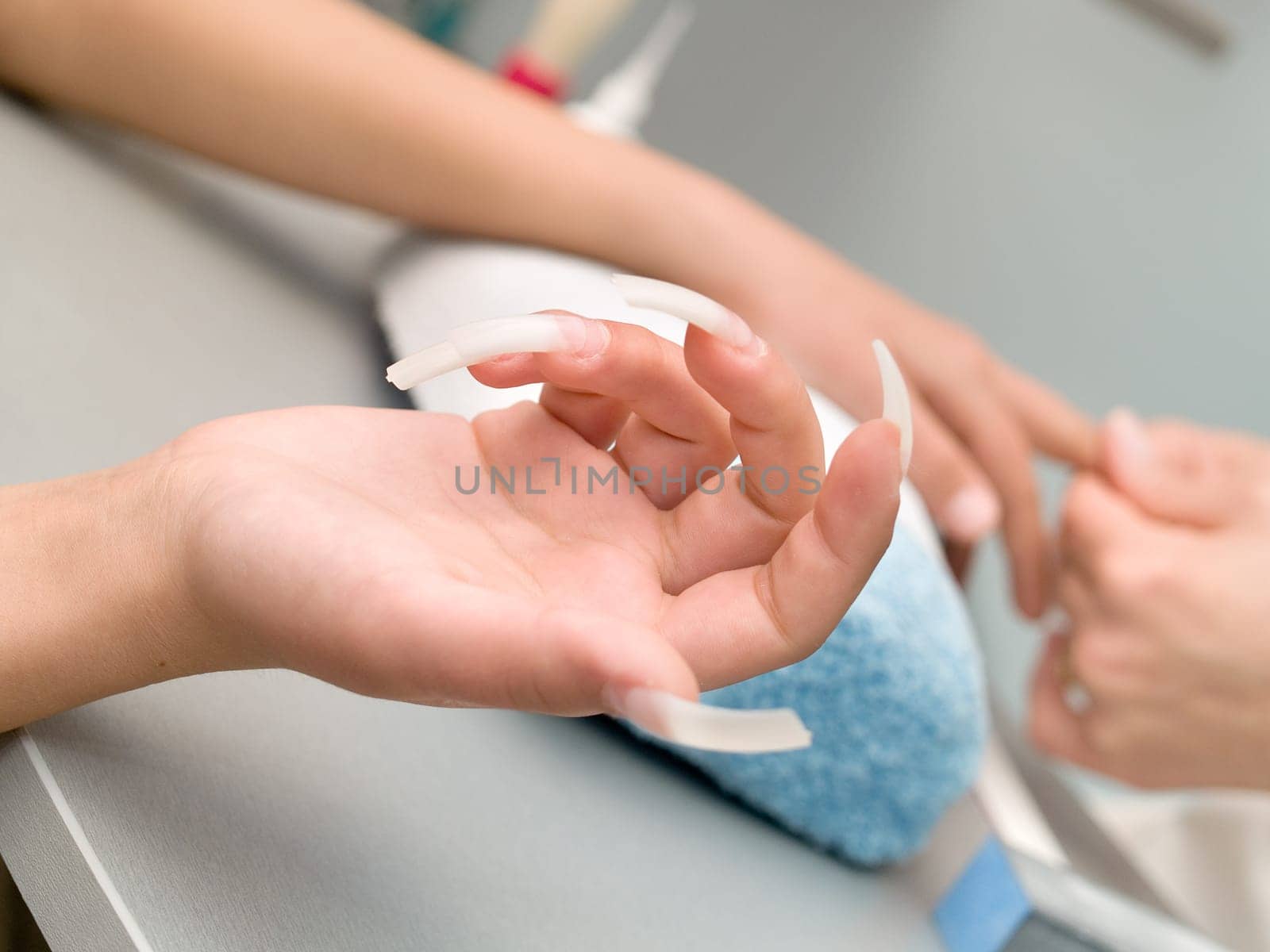 Girl fingernails being manicured.