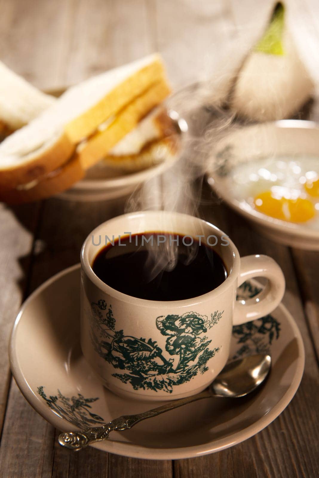 Traditional kopitiam style Malaysian coffee and breakfast with morning sunlight. Fractal on the cup is generic print. Soft focus dramatic ambient light over wood table.