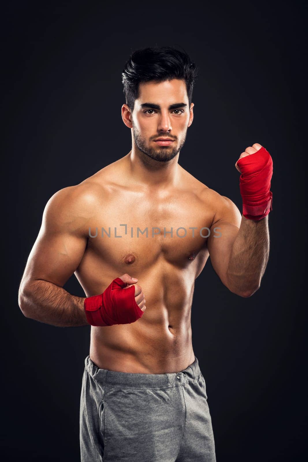 Portrait of a young male Body Combat atlhlete, jumping and kicking