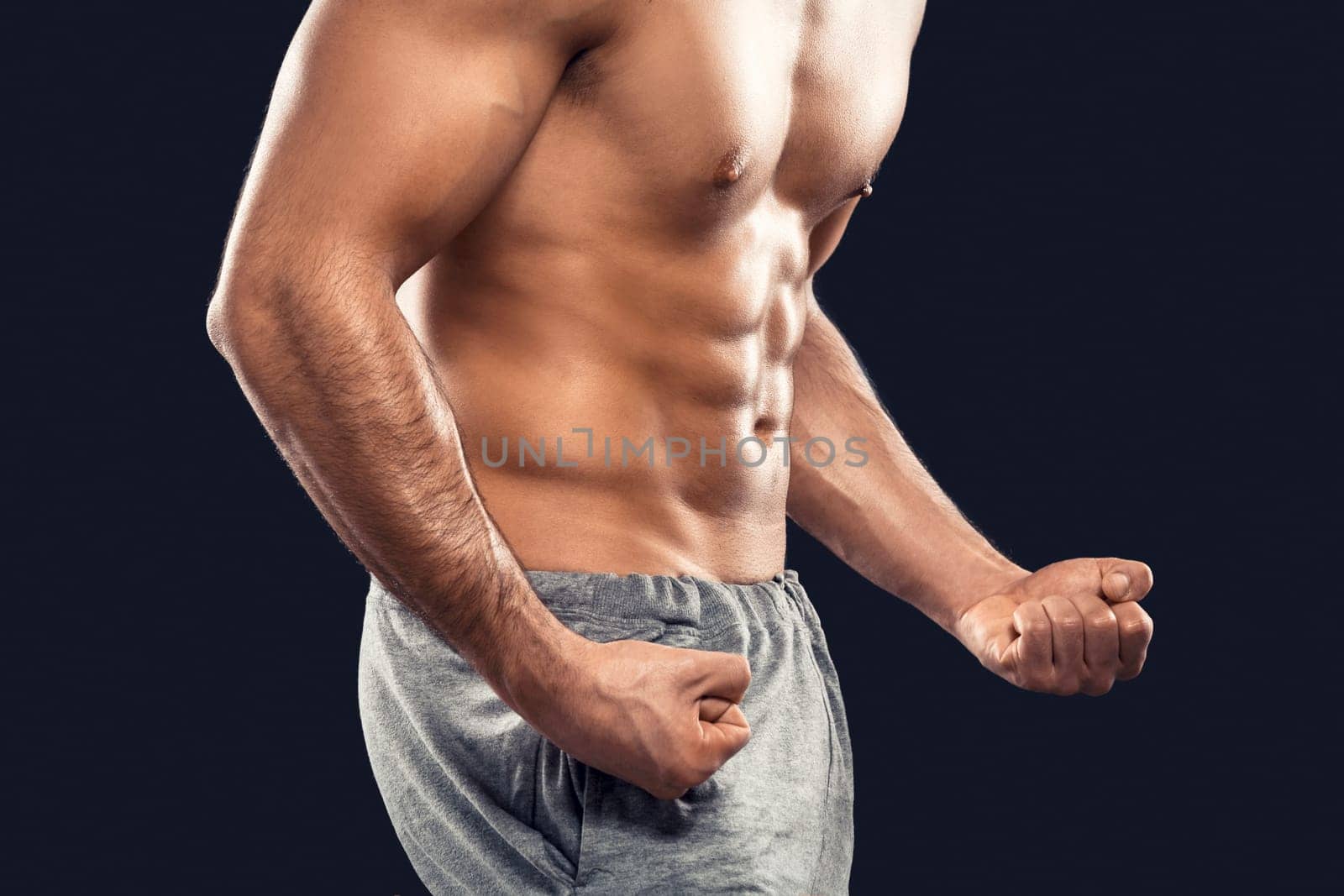Handsome and sexy muscular man, isolated over gray background