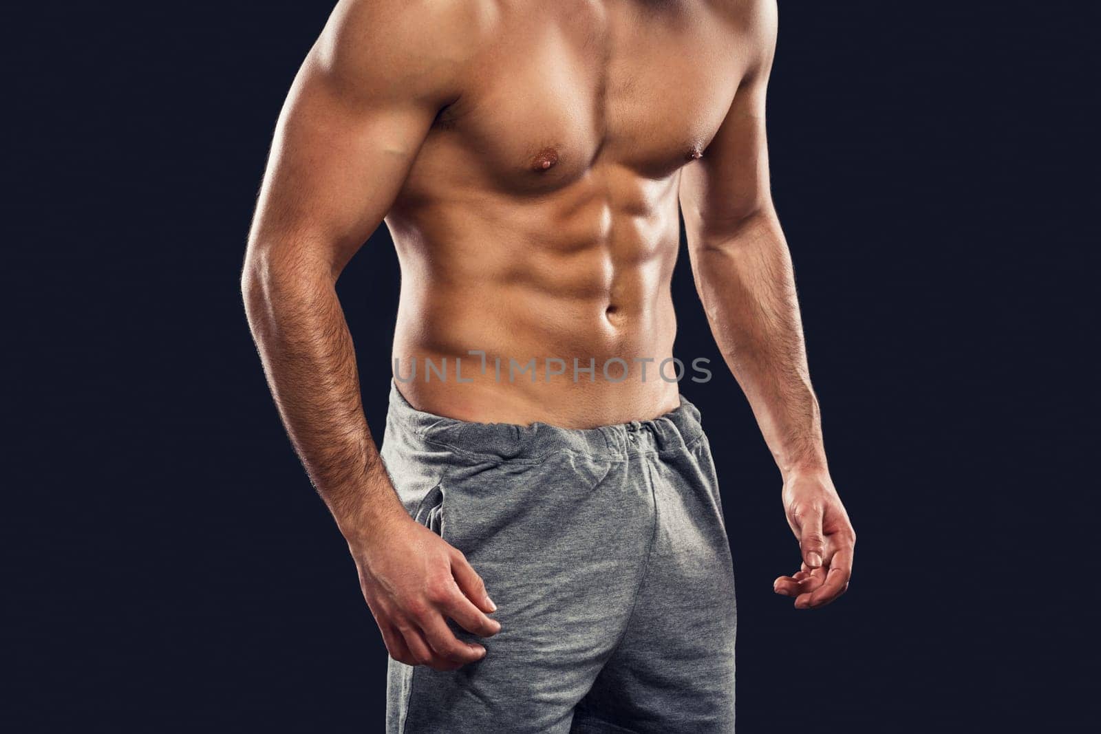 Handsome and sexy muscular man, isolated over gray background