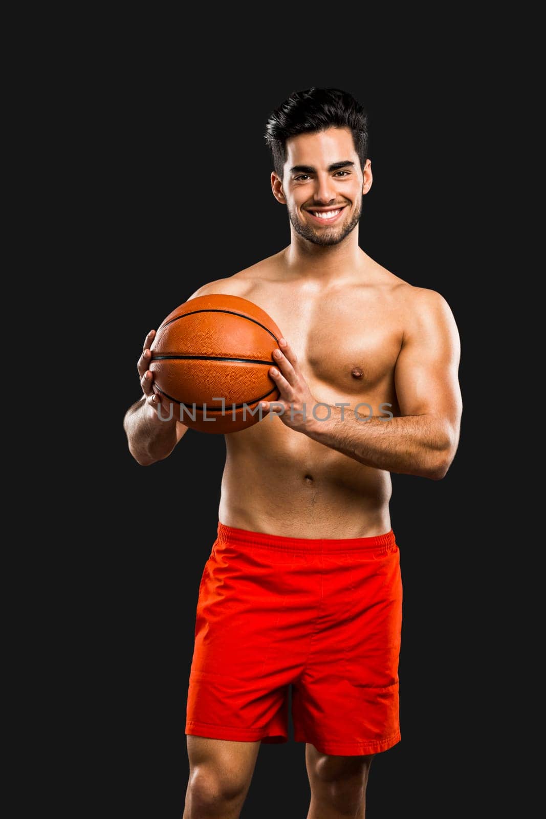 Handsome and sexy muscular man, isolated over gray background