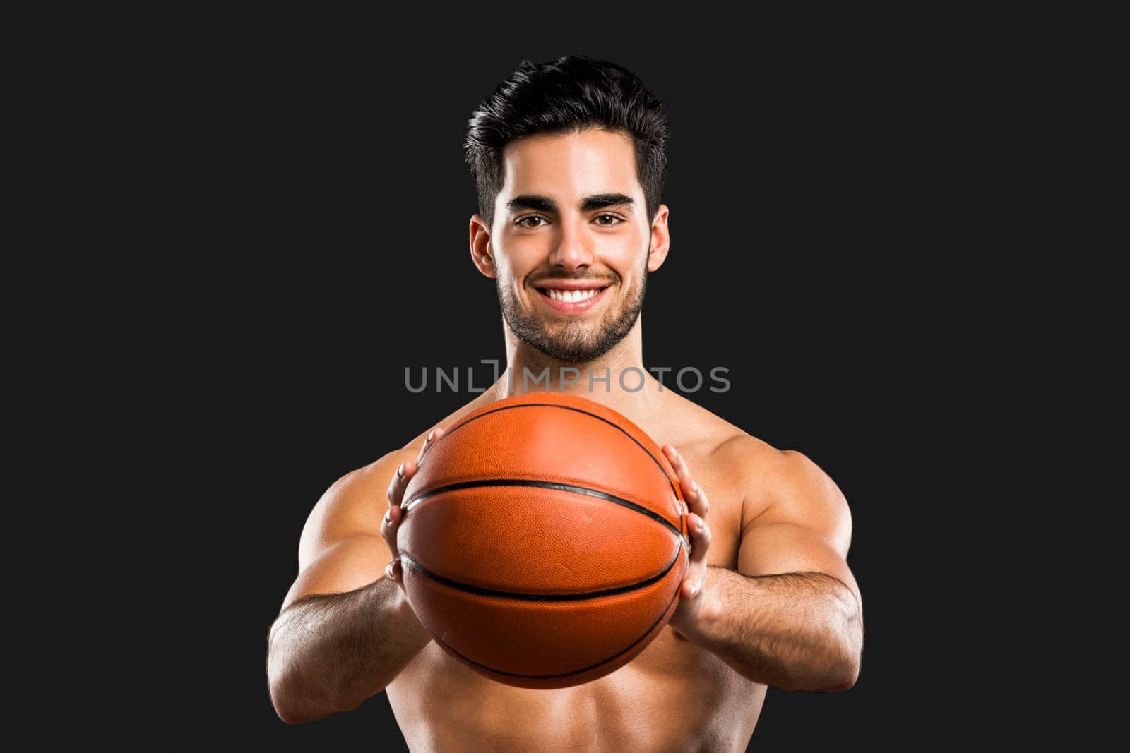 Portrait of a handsome basketball player, isolated over a gray background