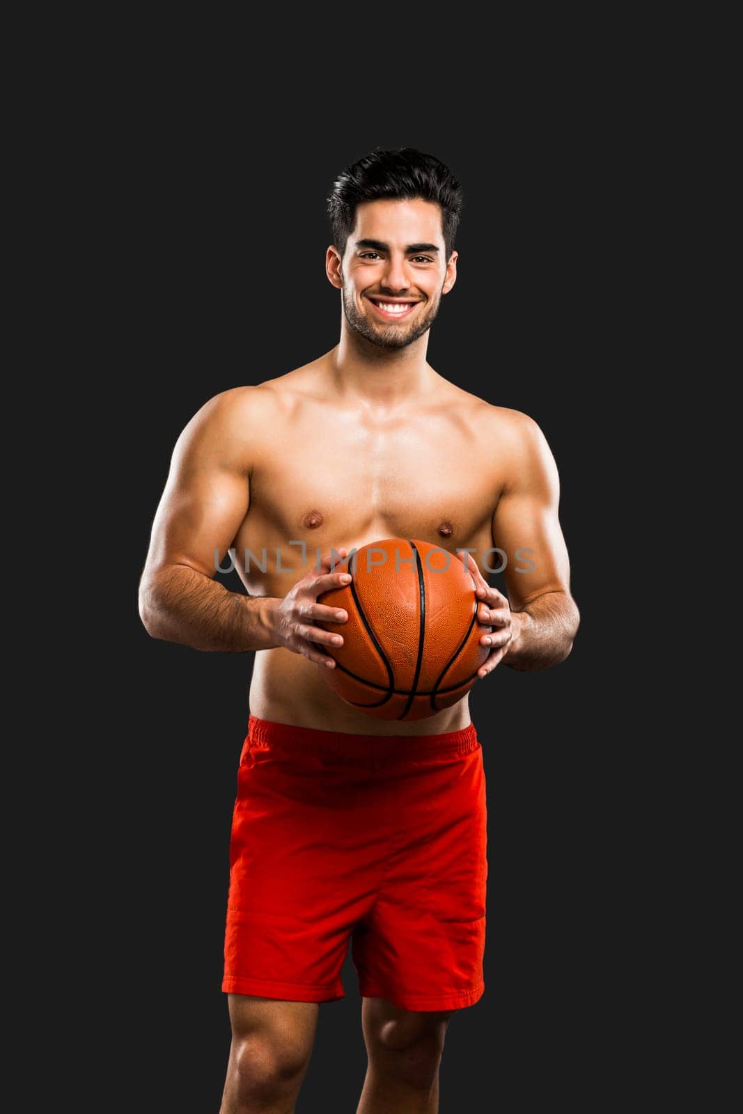 Handsome and sexy muscular man, isolated over gray background