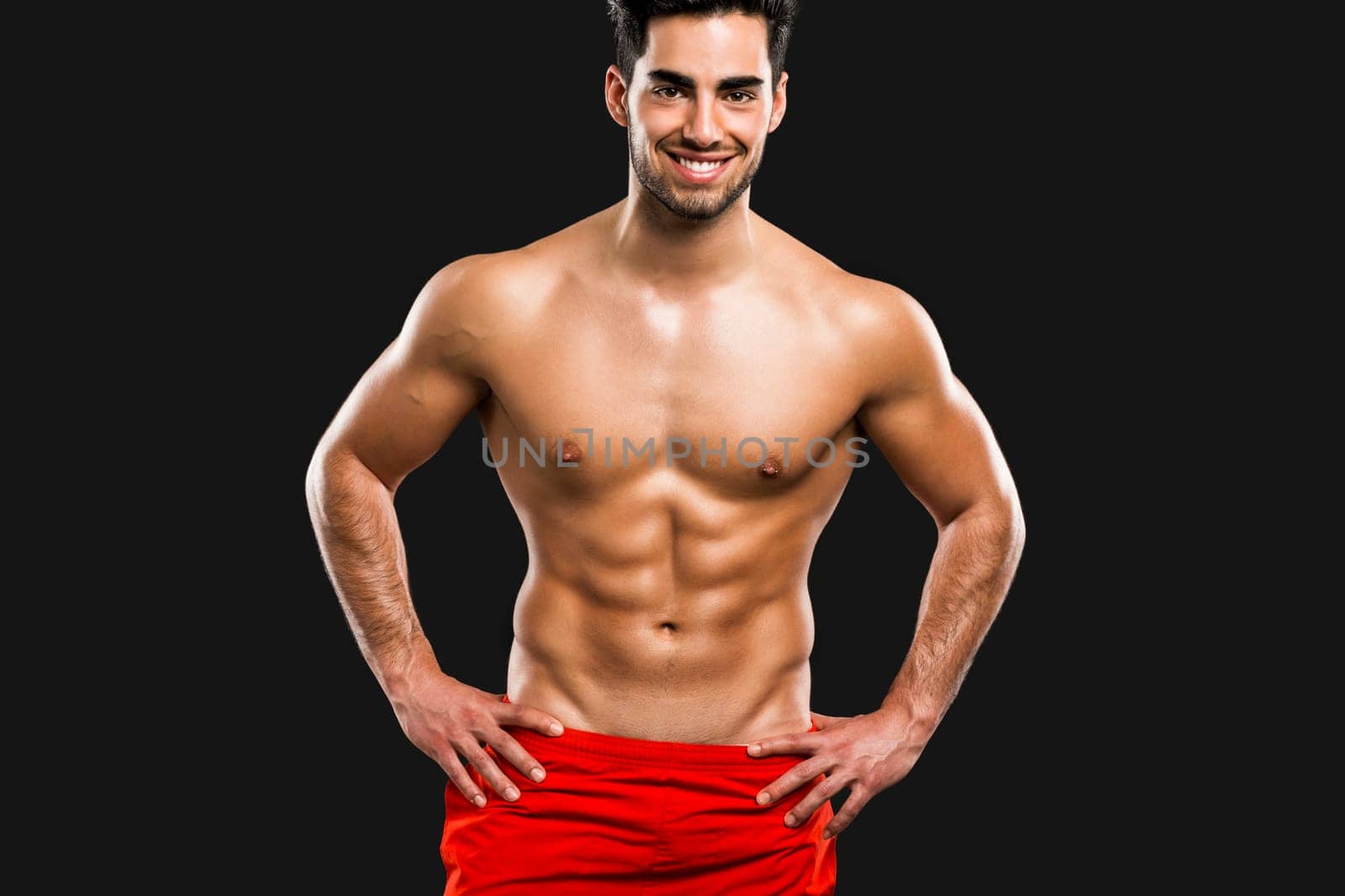 Handsome and sexy muscular man, isolated over gray background