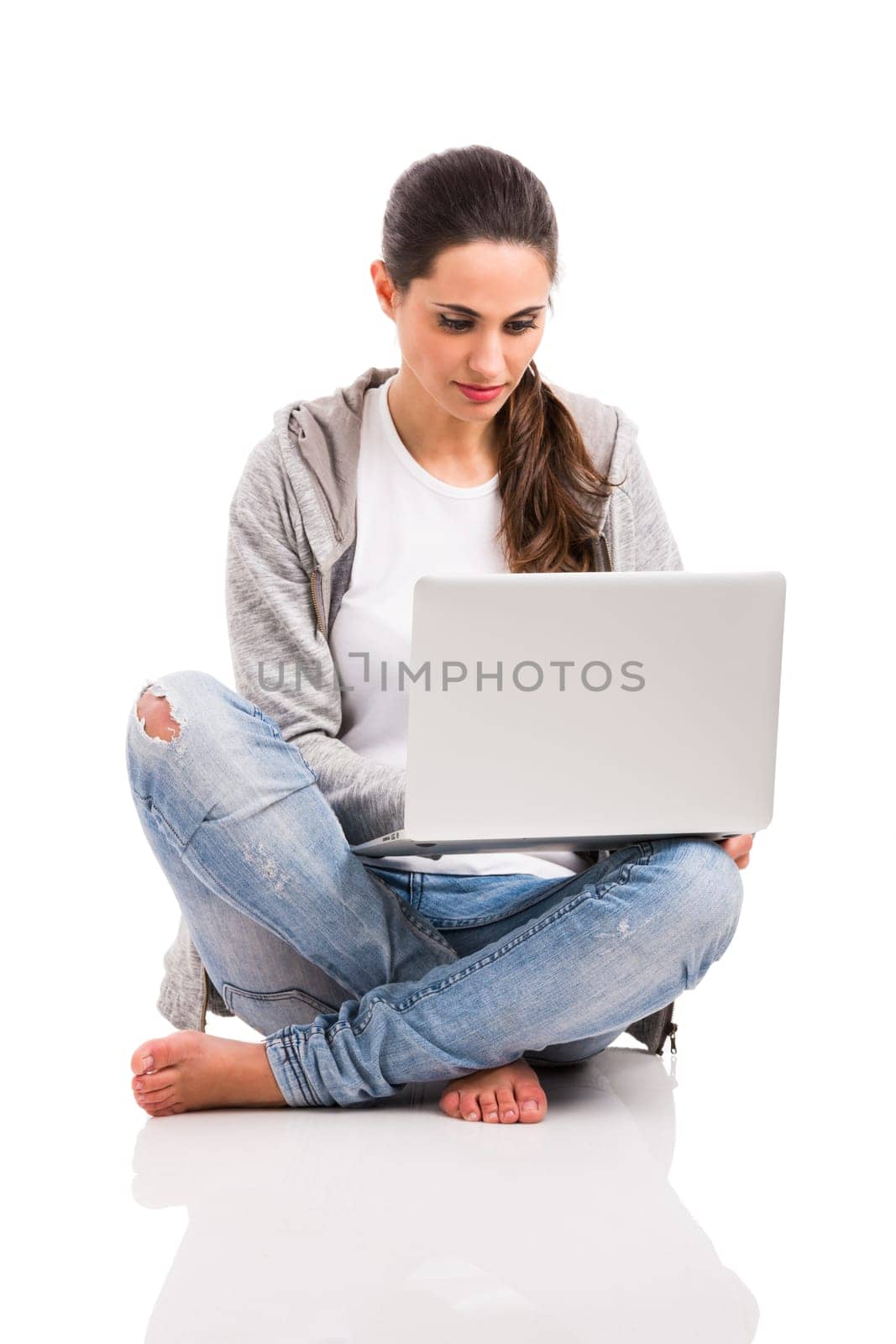 Beautiful woman sitting with crossed legs working with a laptop