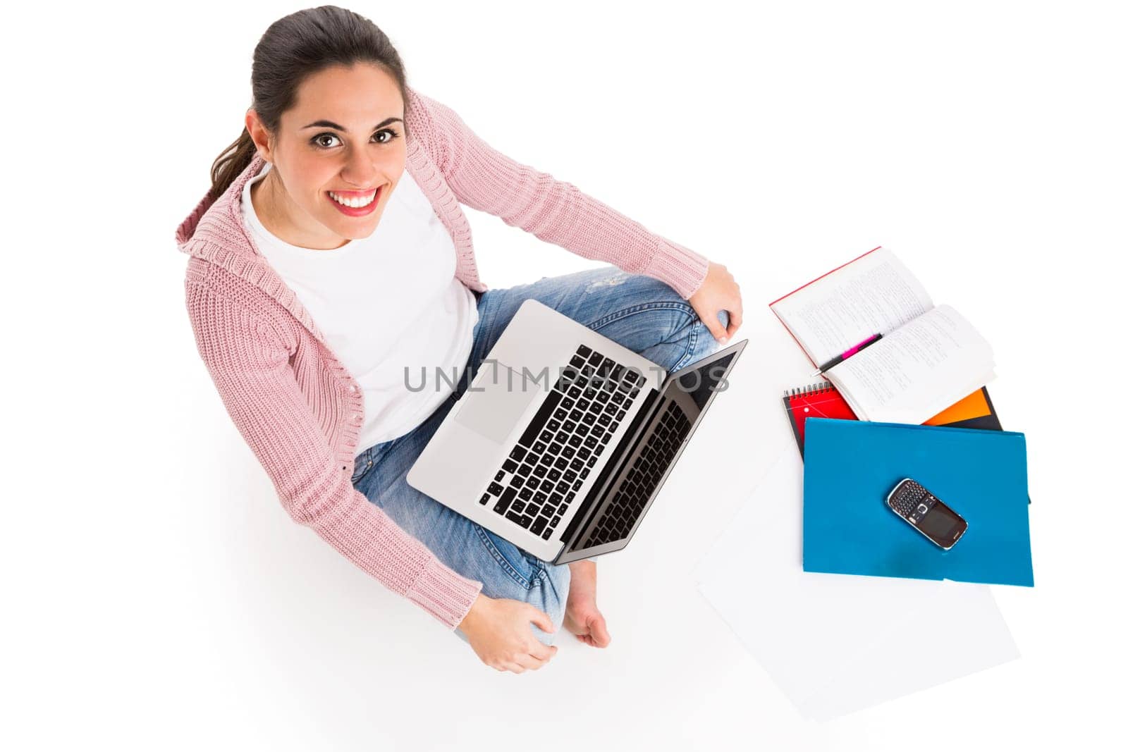 Young female student working with a laptop while drinking coffee, isolated over white background