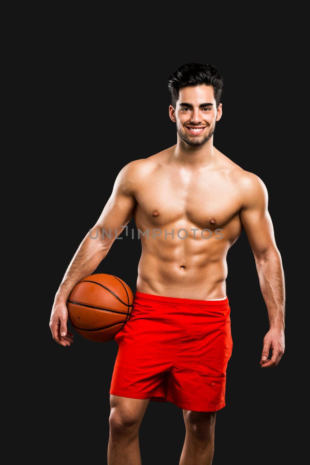 Handsome and sexy muscular man, isolated over gray background