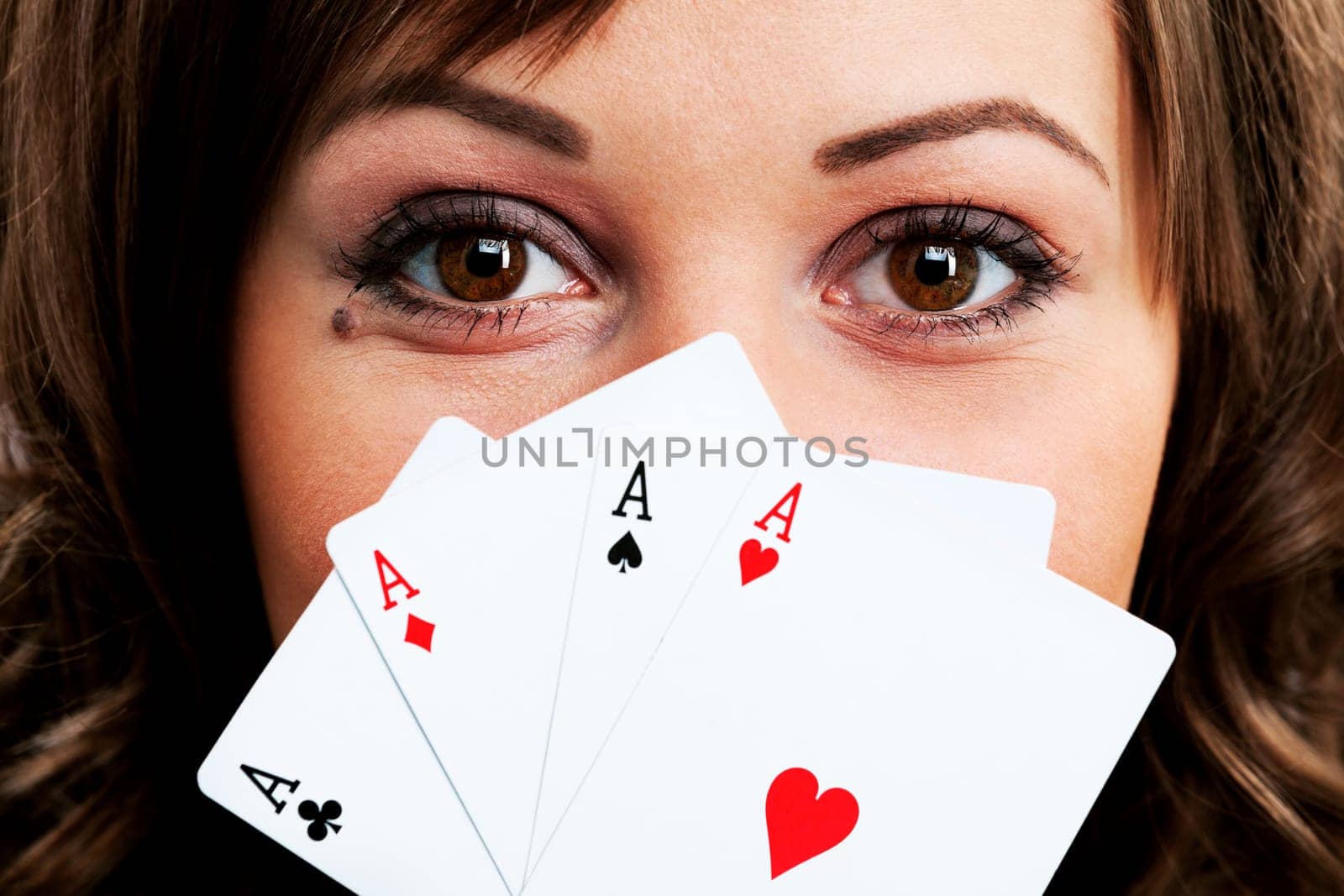 Young woman holding four aces in front of her face