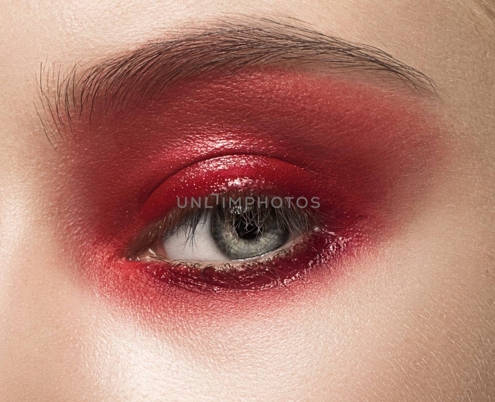 Close-up shot of female eye with red makeup
