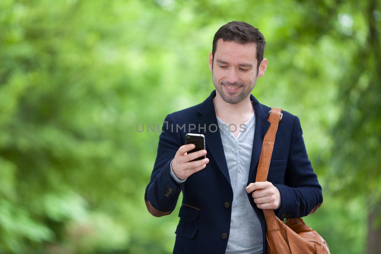 Young attractive man using smartphone in Paris, France