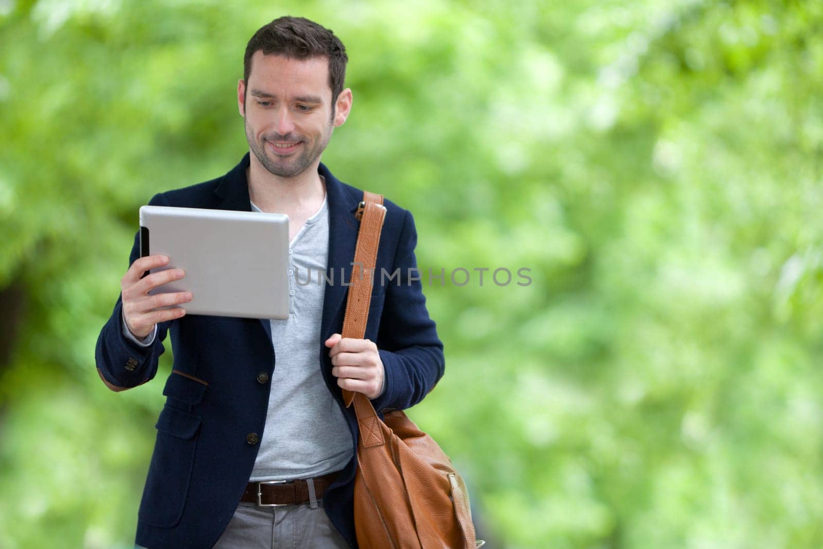 View of a Young attractive man using tablet in Paris, France