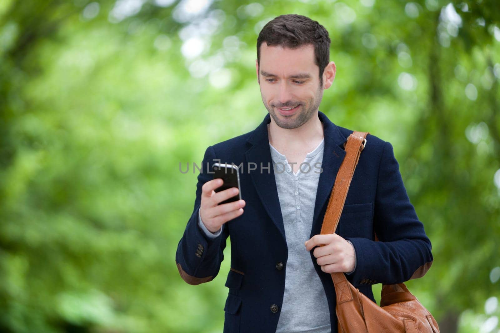 Young attractive man using smartphone in Paris, France