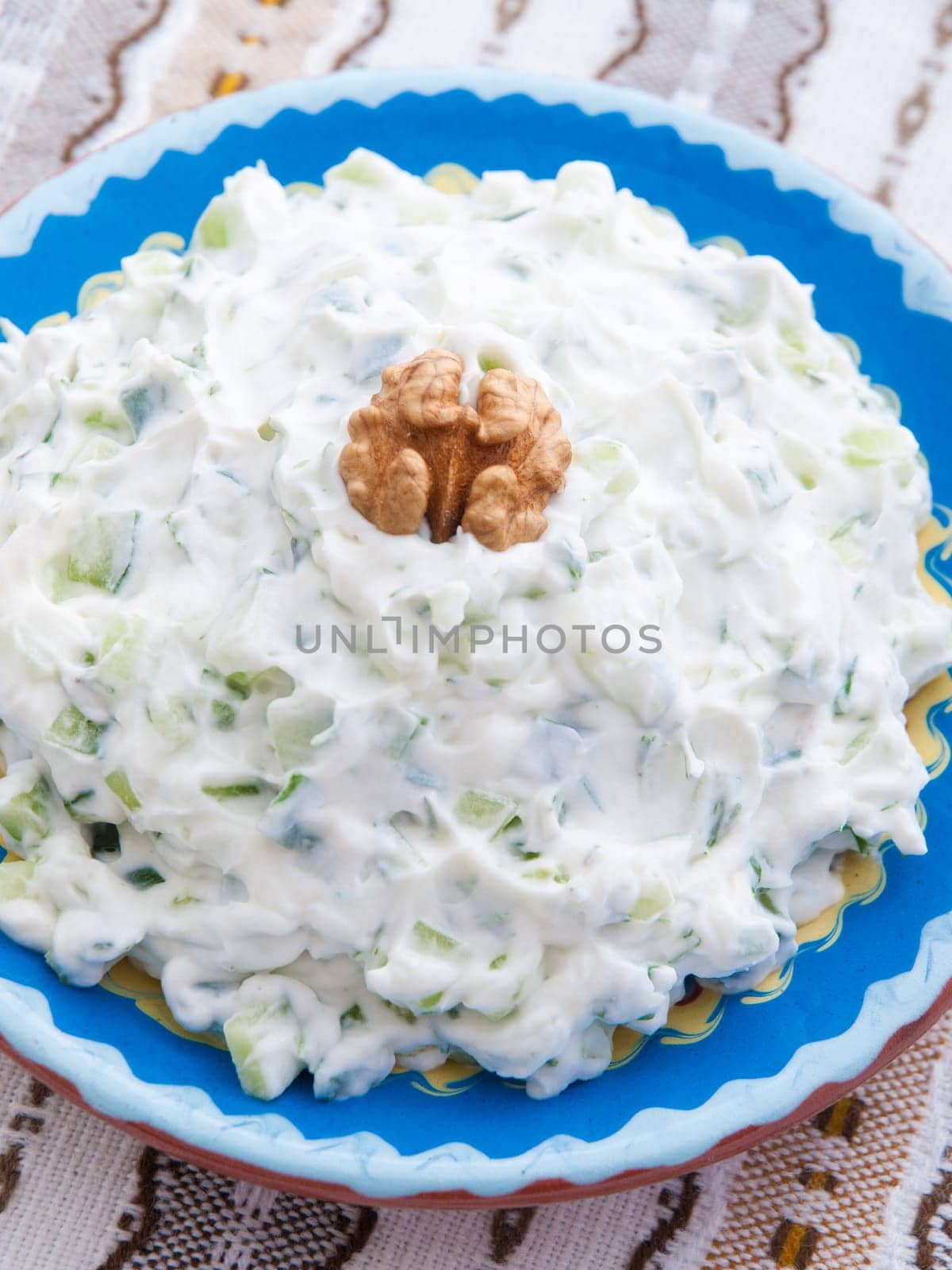 Tzatziki is appetizer from the Greek cuisine made of strained yogurt with cucumbers, garlic and fresh green herbs