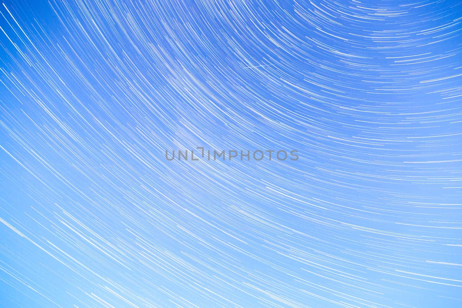Star Trails streaking across a Blue Sky.