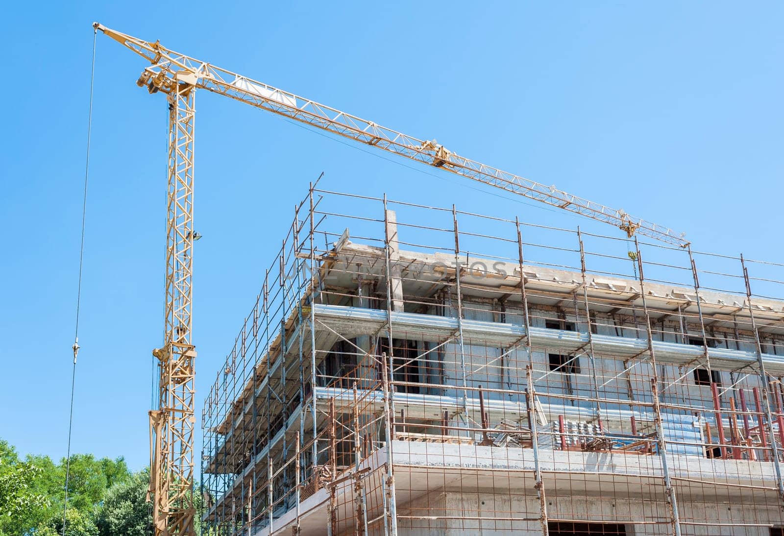Building under construction with crane and scaffolding