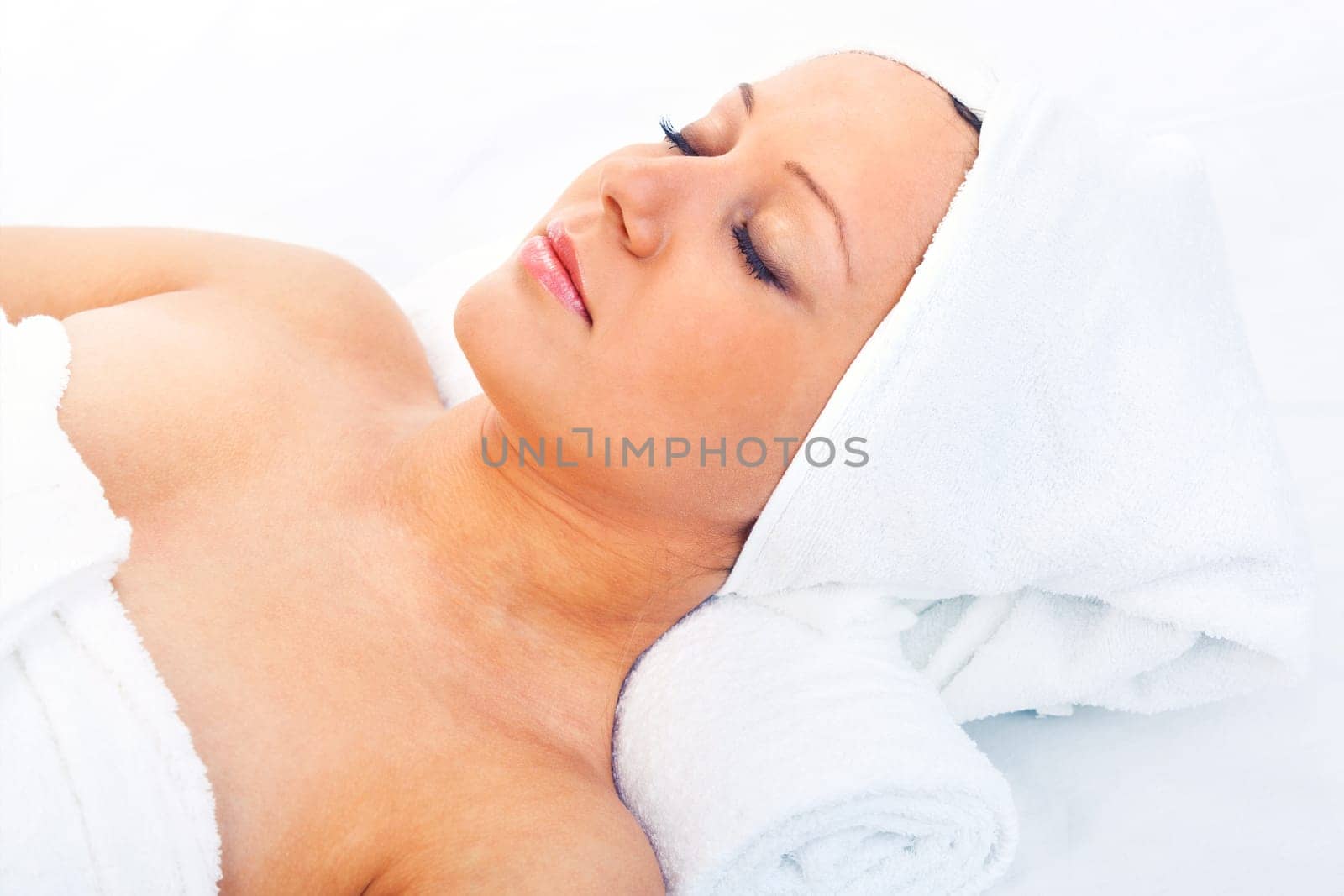 Young woman having a classical massage lying on white bed