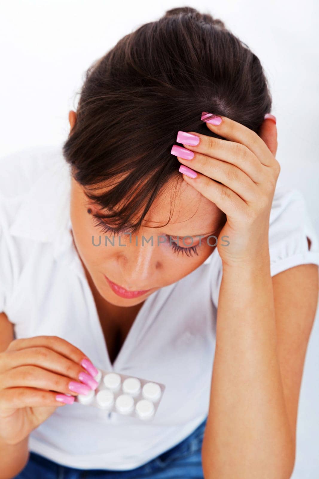 Young woman taking a pill isolated on white background