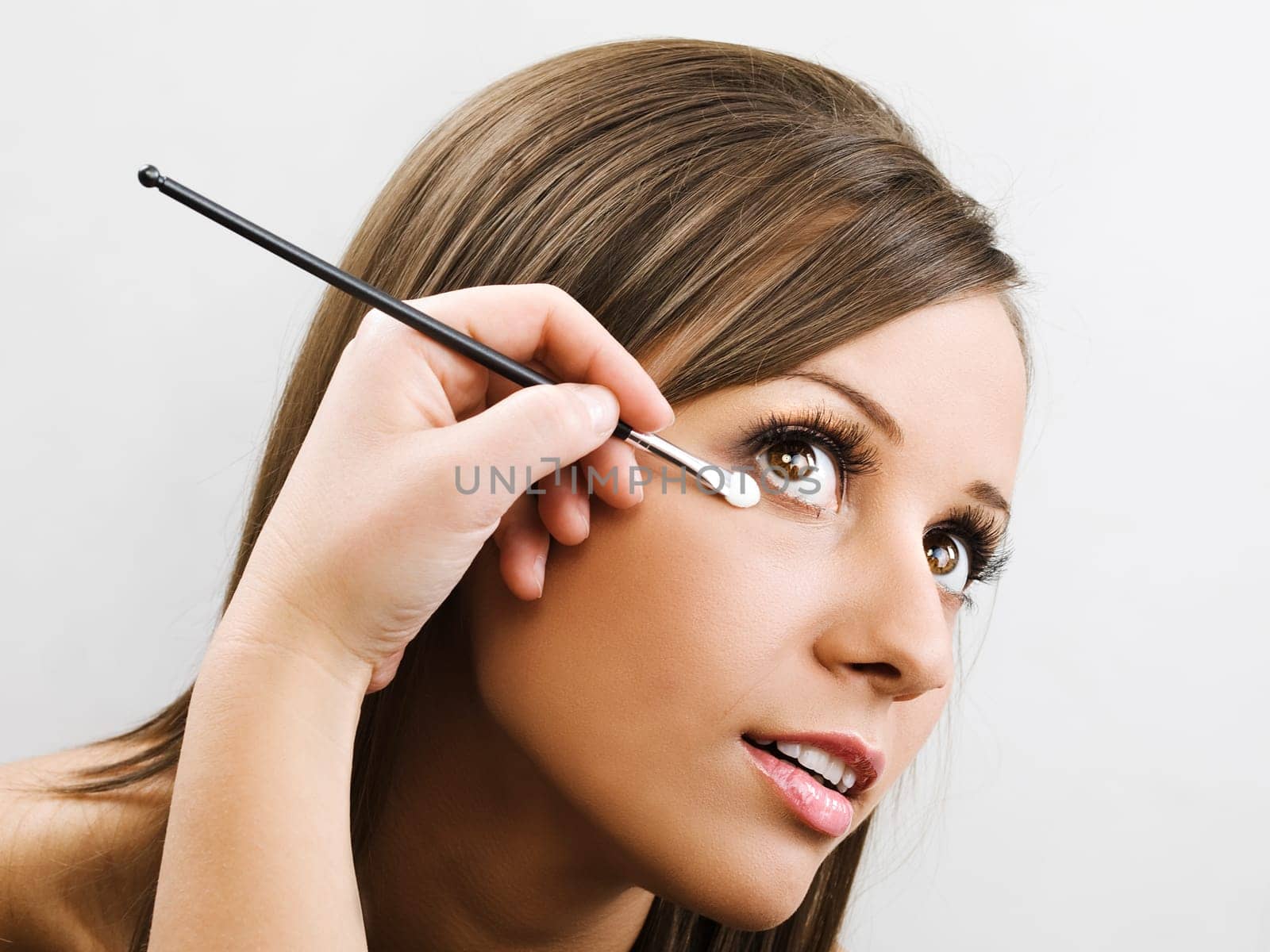 Applying make up on young woman