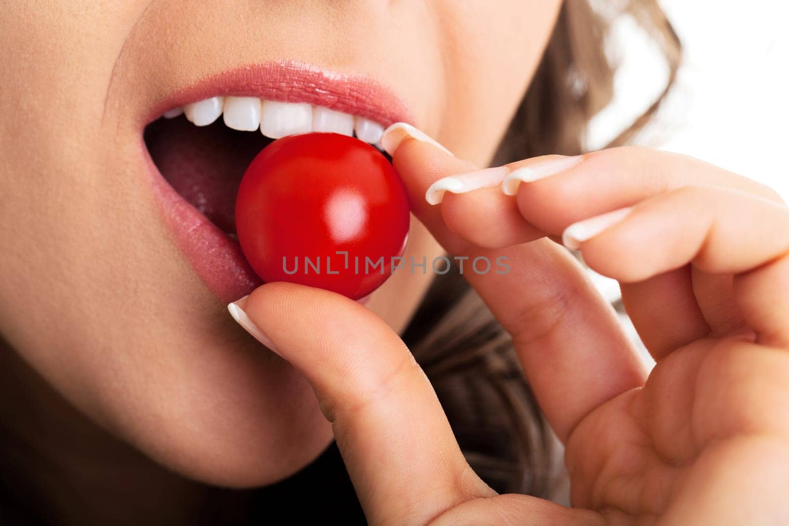 Young woman eating cherry tomato, close up