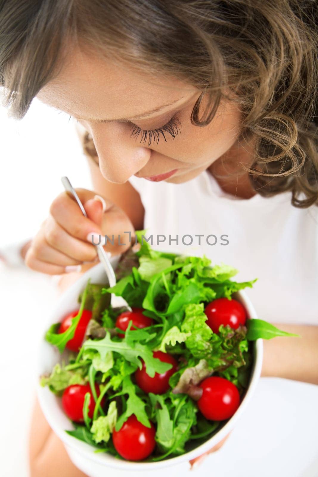 Youg woman eating healthy salad isolated on white background