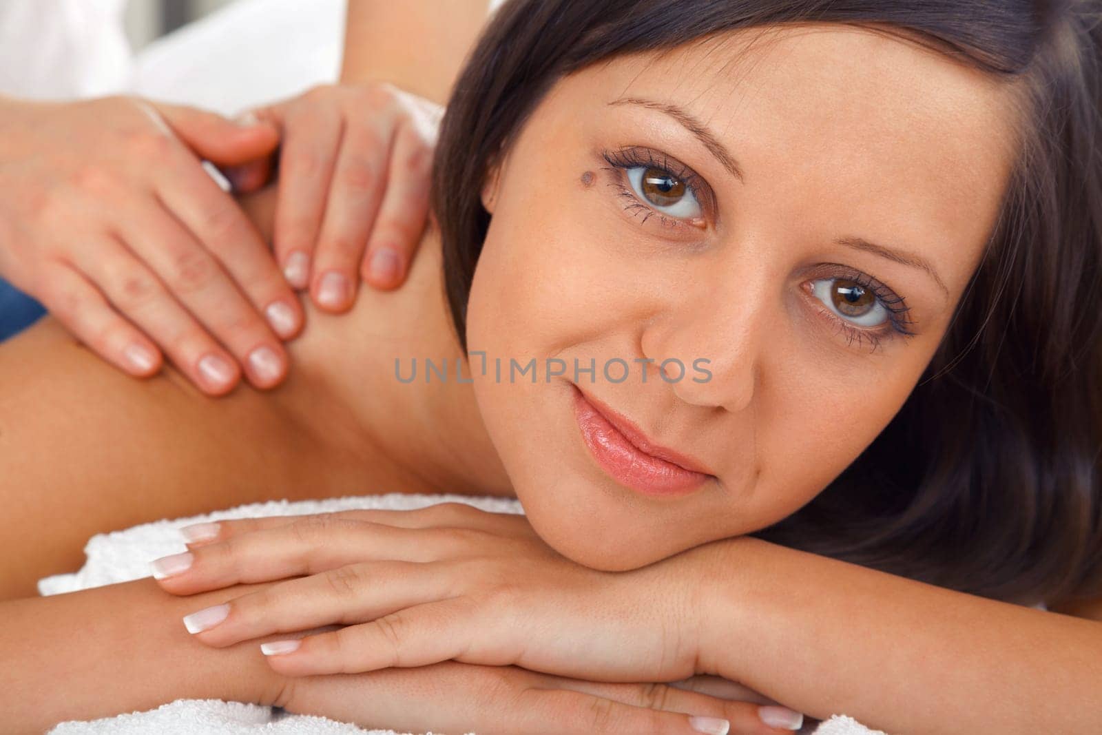 Young woman having a classical massage lying on white bed