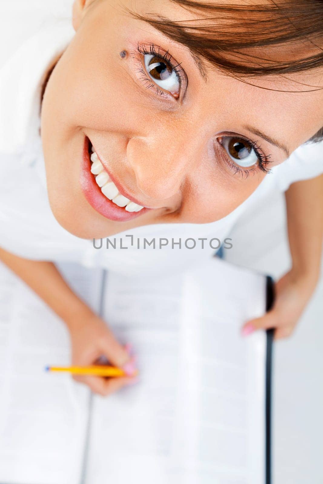 Young woman taking notes sitting on the bed isolated on white background