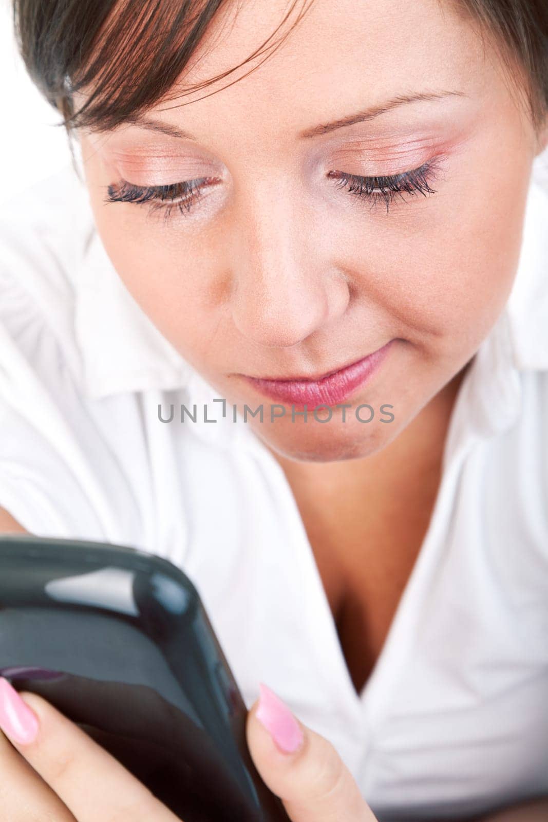 Young woman lying in bed and talking on the phone isolated on white background