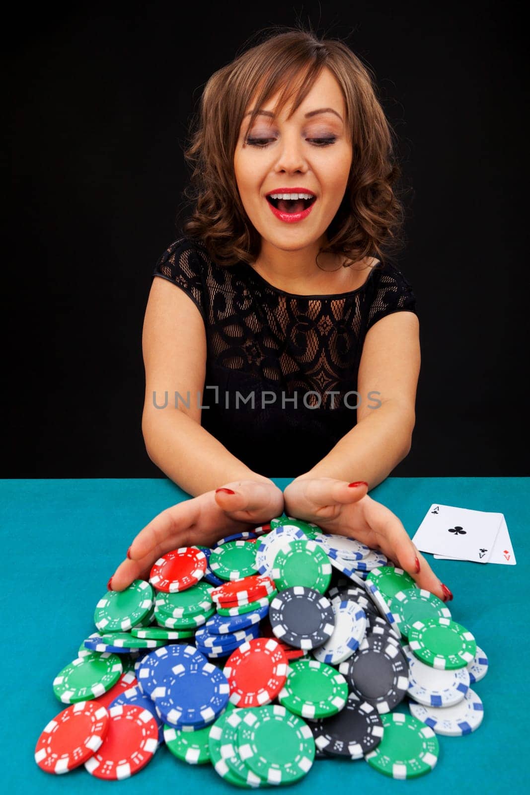 Young woman holding gambling chips on black background