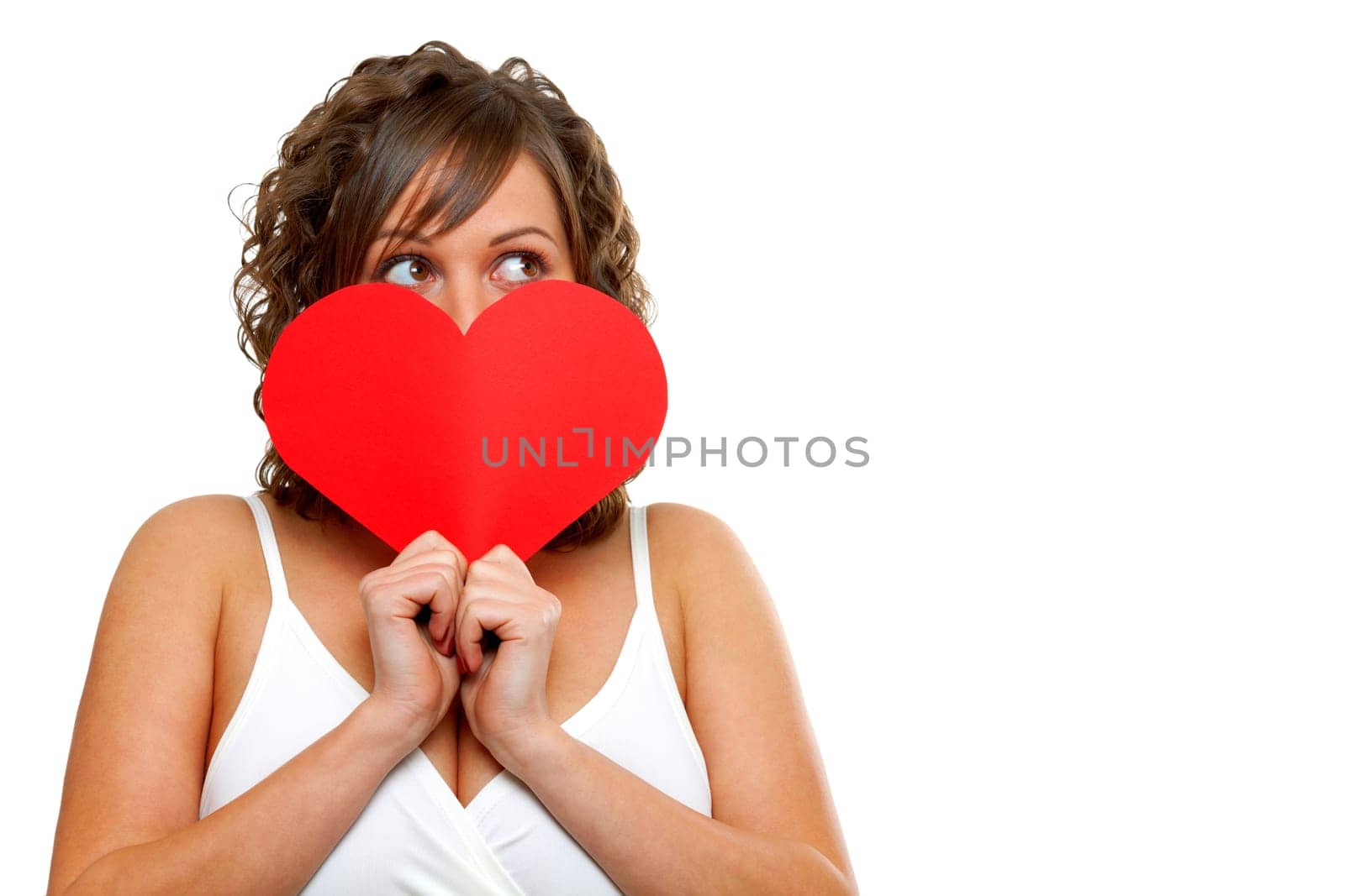 Young attractive woman holding red paper heart like a valentine card and hiding her face