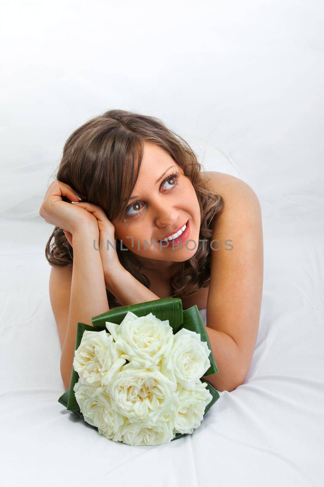 Young bride with a wedding bouquet isolated on white background looking away dreaming for future