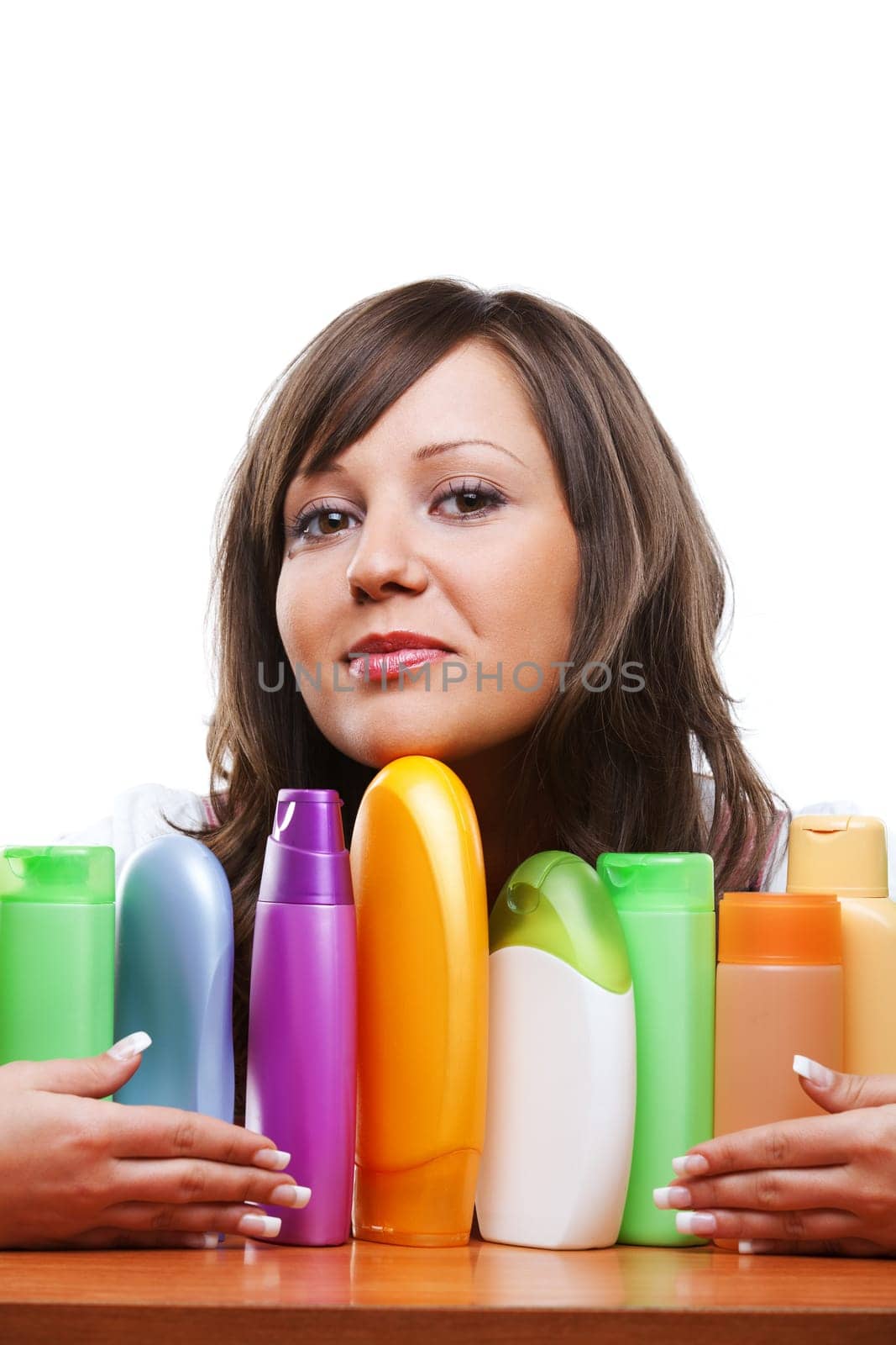 Young woman trying to choose which shampoo to buy, isolated on white background